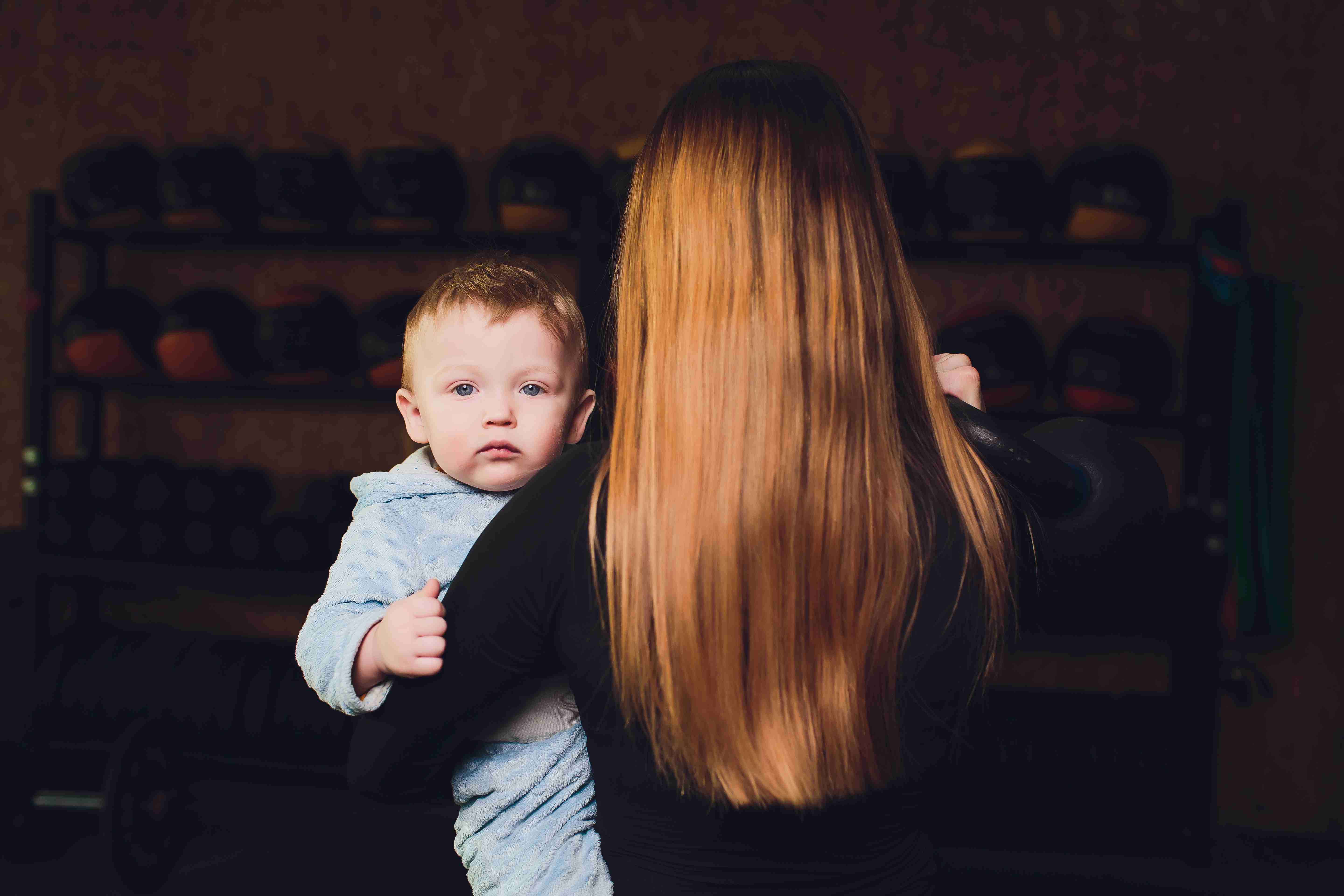 A Mother holding her baby,  showing long, healthy hair after postpartum recovery.